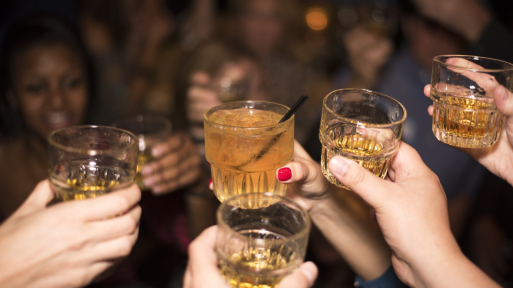 a group of people toasting with drinks at a party