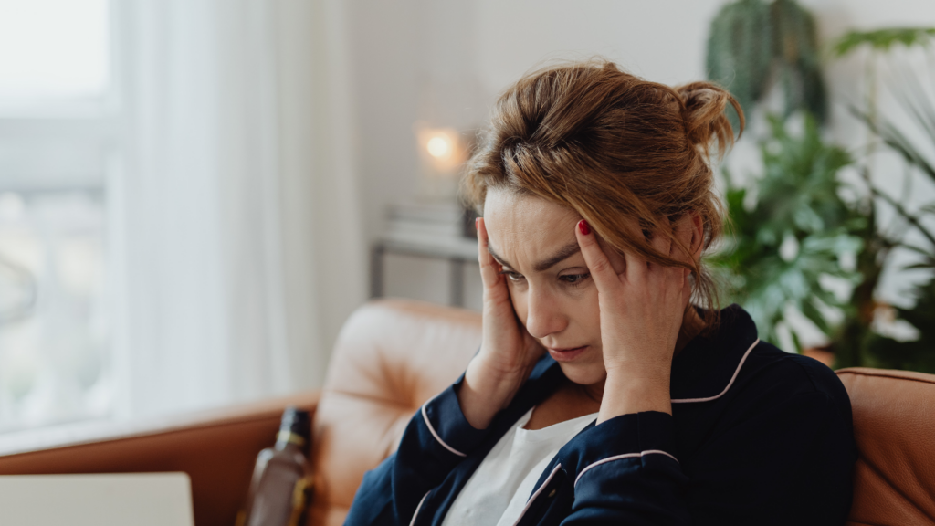 a person sitting on a couch with their head in their hands