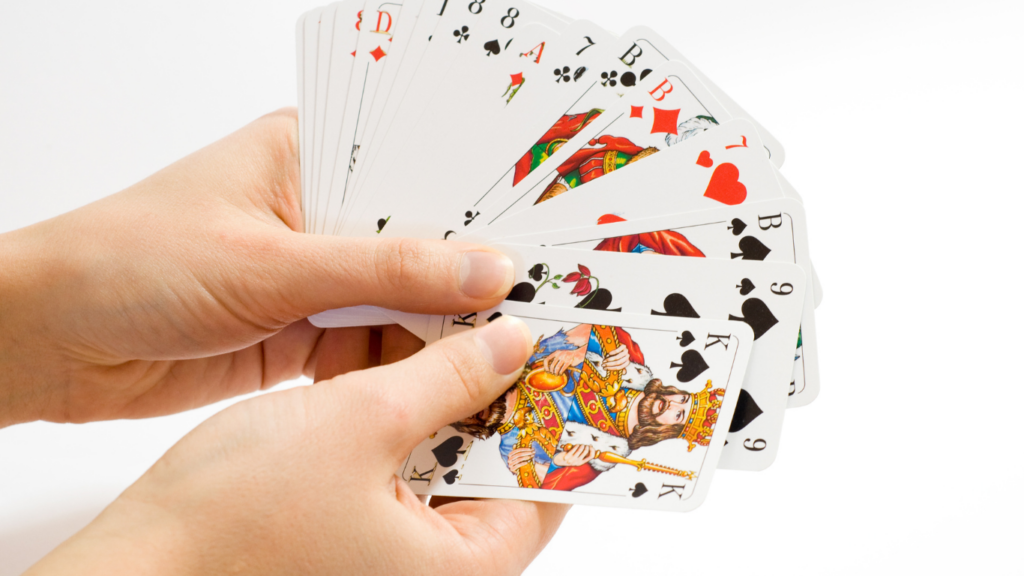 a person holding a playing cards