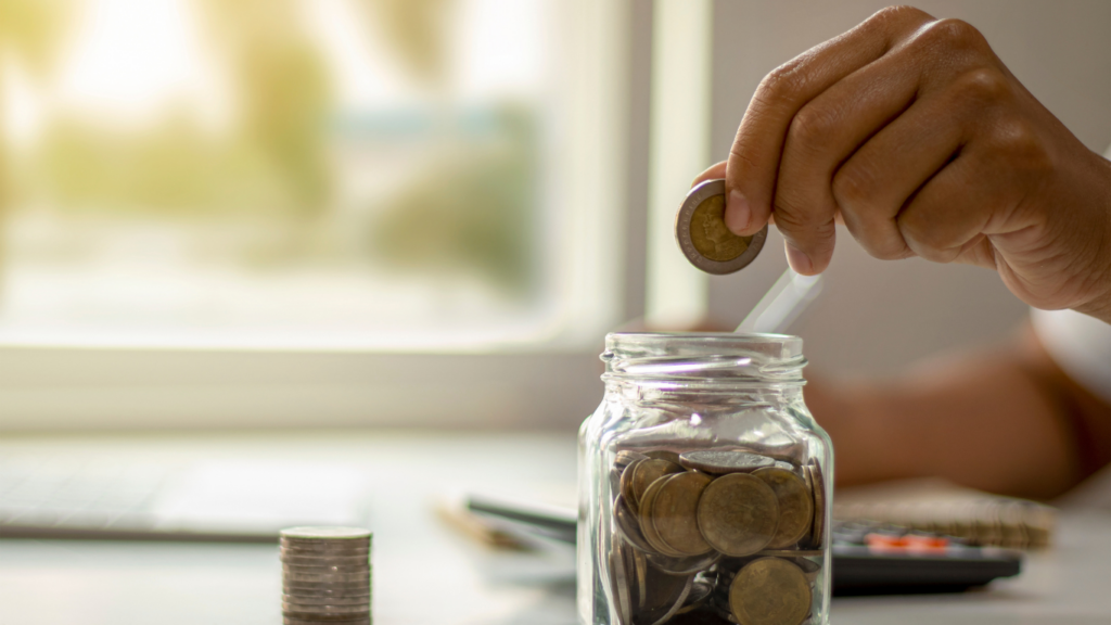 a person putting coins in a jar