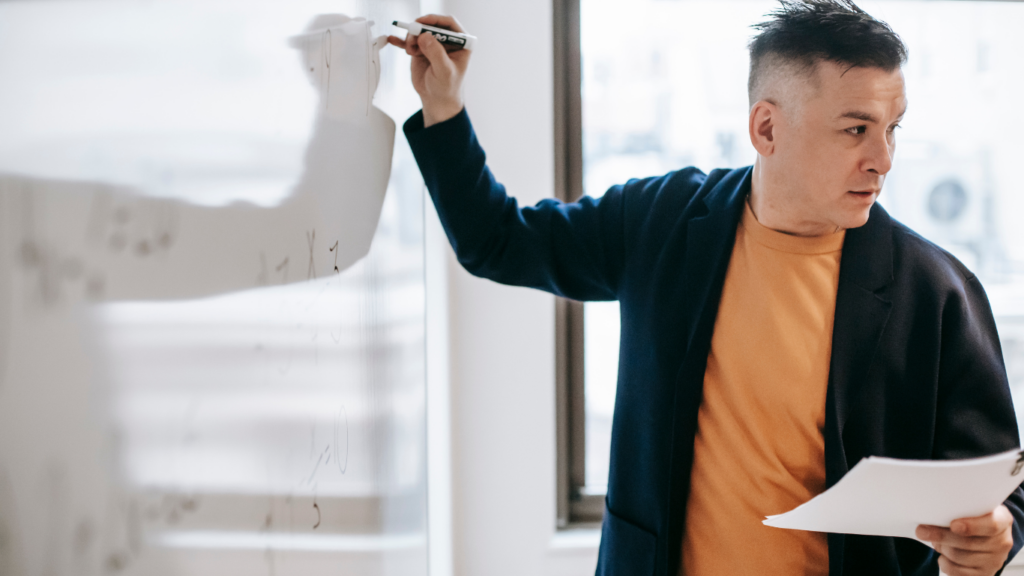 a person writing in whiteboard