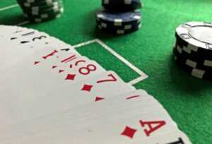 Close-up view of poker cards and chips on a green felt table, perfect for casino-themed content.